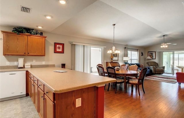 kitchen featuring light countertops, open floor plan, vaulted ceiling, dishwasher, and a peninsula