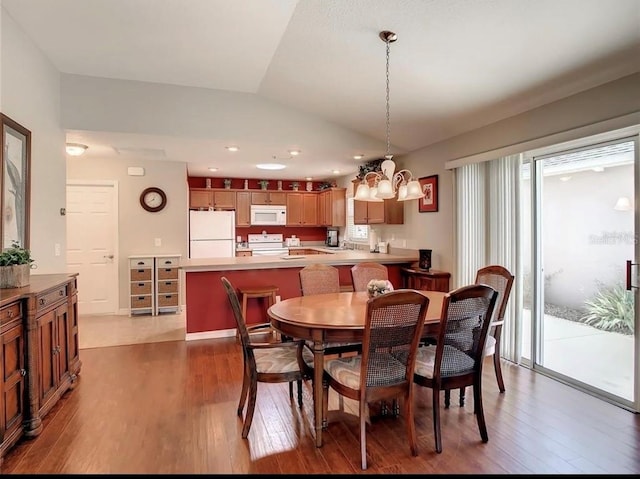 dining space featuring lofted ceiling and dark wood-style flooring