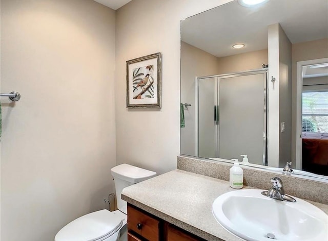 bathroom featuring a shower stall, toilet, and vanity