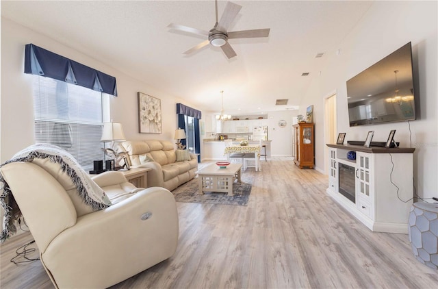 living room with a wealth of natural light, light wood-type flooring, baseboards, and ceiling fan with notable chandelier