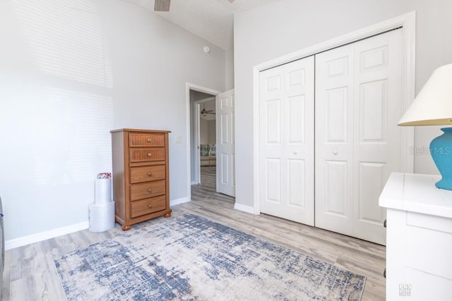 bedroom featuring a textured ceiling, a closet, baseboards, and wood finished floors