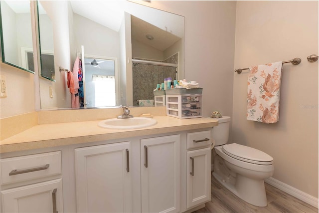 bathroom with toilet, a stall shower, vaulted ceiling, vanity, and wood finished floors