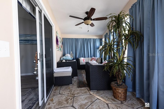 sunroom / solarium featuring a ceiling fan