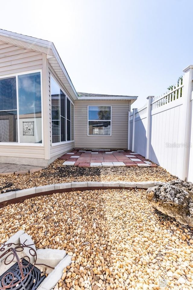 back of property with fence and a patio