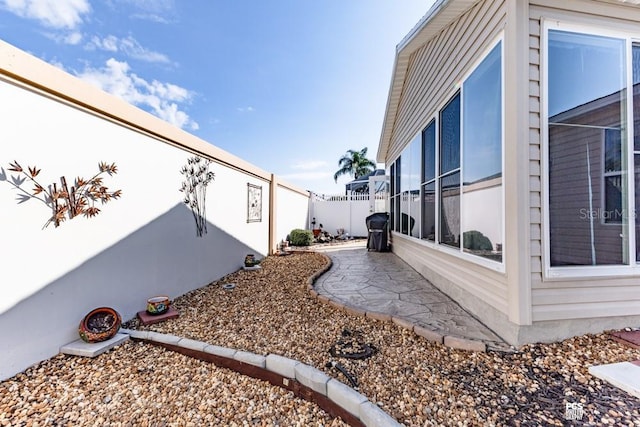 view of side of property with fence and a patio