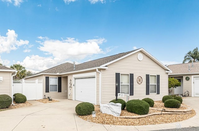 ranch-style home with an attached garage, a shingled roof, driveway, and fence