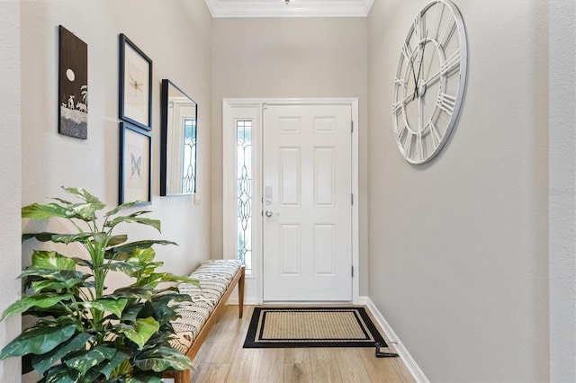 entryway with ornamental molding, baseboards, and wood finished floors