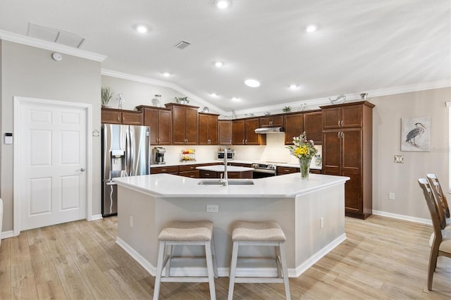 kitchen with visible vents, appliances with stainless steel finishes, crown molding, under cabinet range hood, and a sink