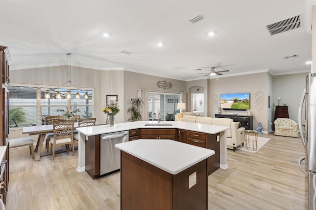 kitchen with a sink, stainless steel appliances, a kitchen island, and visible vents