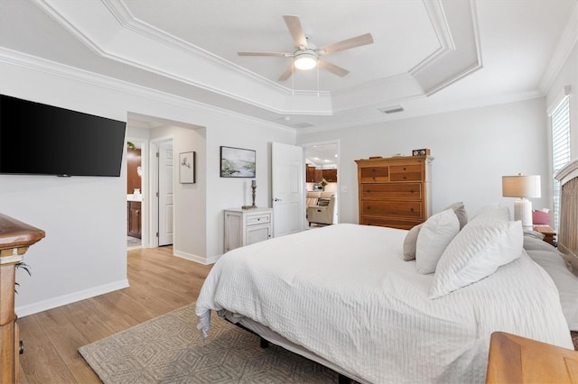 bedroom with baseboards, visible vents, a raised ceiling, ornamental molding, and light wood-type flooring