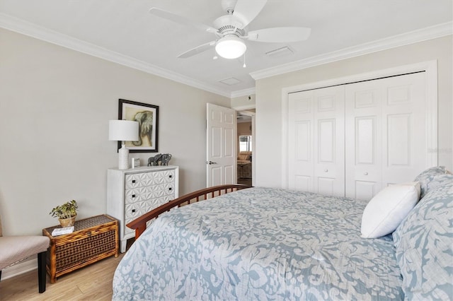 bedroom with light wood-style flooring, a closet, ceiling fan, and crown molding