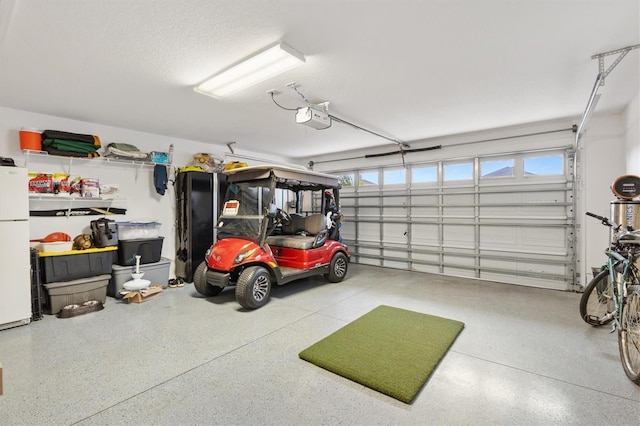 garage featuring a garage door opener and freestanding refrigerator