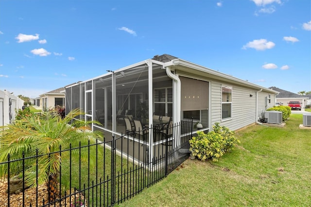 view of home's exterior with glass enclosure, fence, cooling unit, and a yard