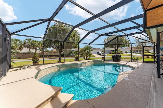 pool featuring glass enclosure, a patio, and a lawn