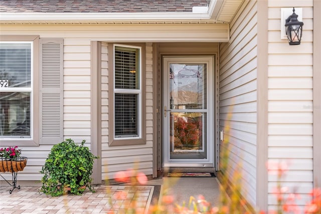 property entrance featuring a shingled roof