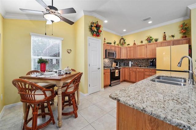 kitchen featuring visible vents, ornamental molding, a sink, tasteful backsplash, and appliances with stainless steel finishes