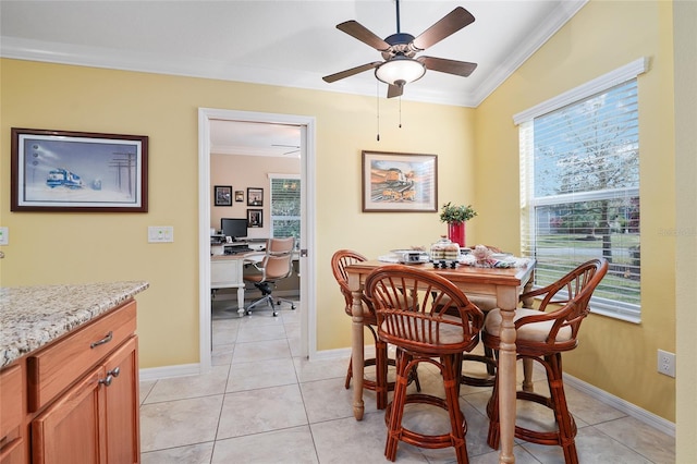 dining area featuring light tile patterned floors, a ceiling fan, crown molding, and baseboards