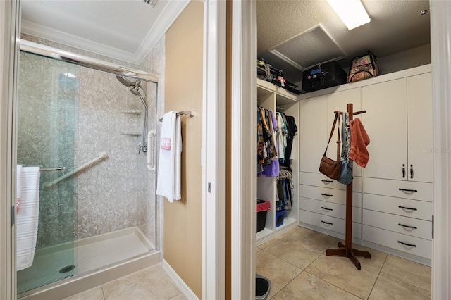 bathroom with a walk in closet, baseboards, crown molding, a stall shower, and tile patterned floors