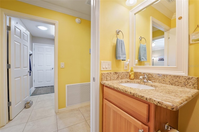 bathroom with visible vents, crown molding, baseboards, tile patterned floors, and vanity