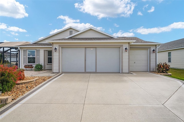 ranch-style house with concrete driveway, an attached garage, and roof with shingles