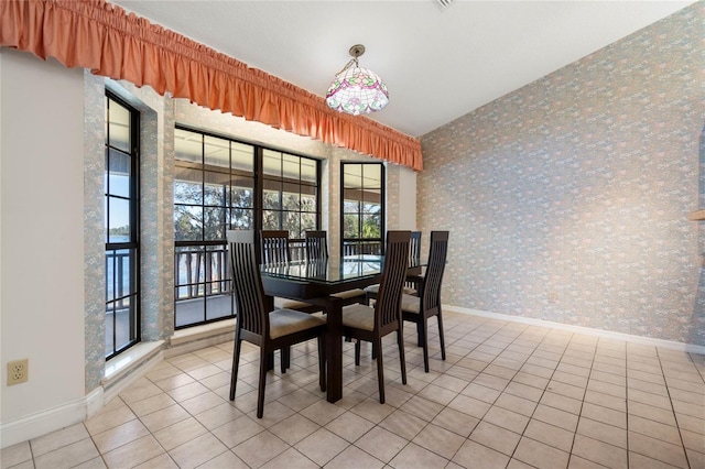 tiled dining room with wallpapered walls and baseboards