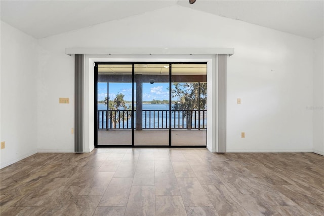 empty room featuring lofted ceiling and baseboards