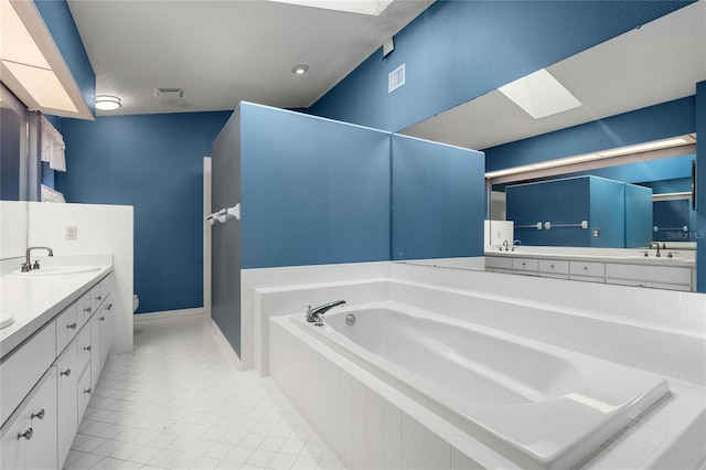 bathroom with a skylight, a sink, visible vents, a bath, and double vanity