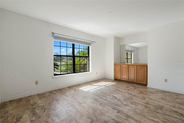 spare room with baseboards