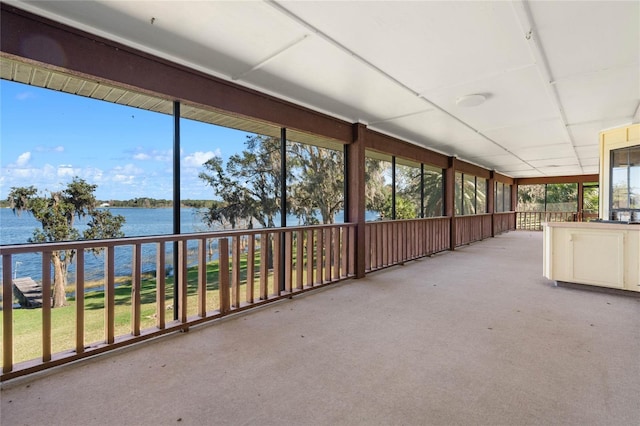 unfurnished sunroom with a water view and a drop ceiling