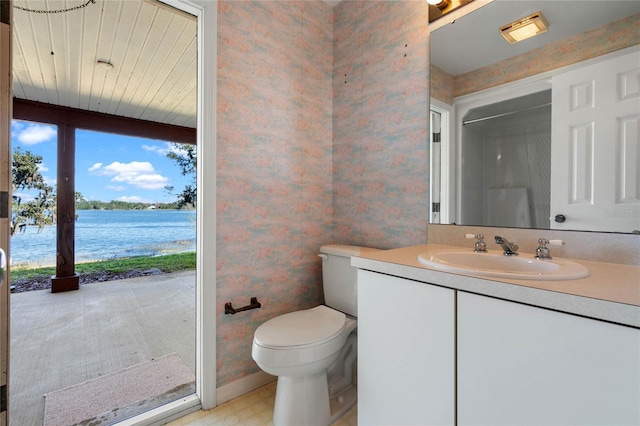 bathroom featuring toilet, vanity, a shower, tile patterned floors, and wallpapered walls