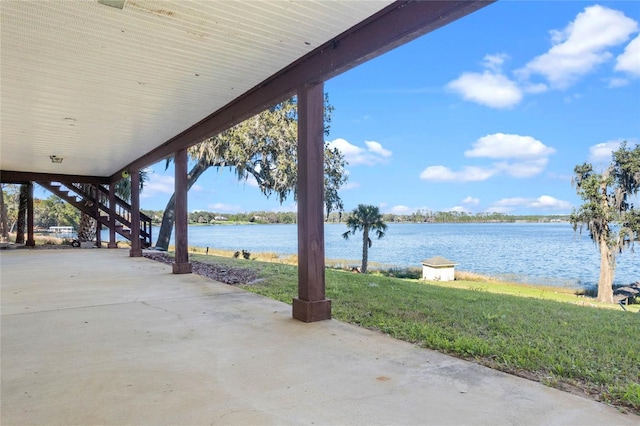 view of patio / terrace featuring a water view and stairs