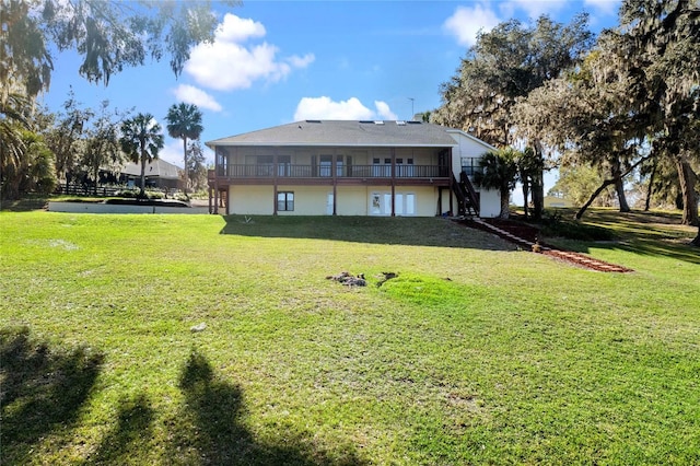 back of house featuring a yard and stairway