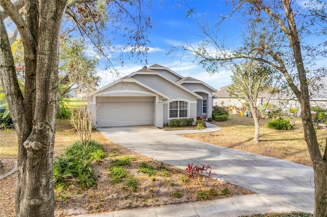 view of front facade featuring driveway, a front lawn, an attached garage, and stucco siding