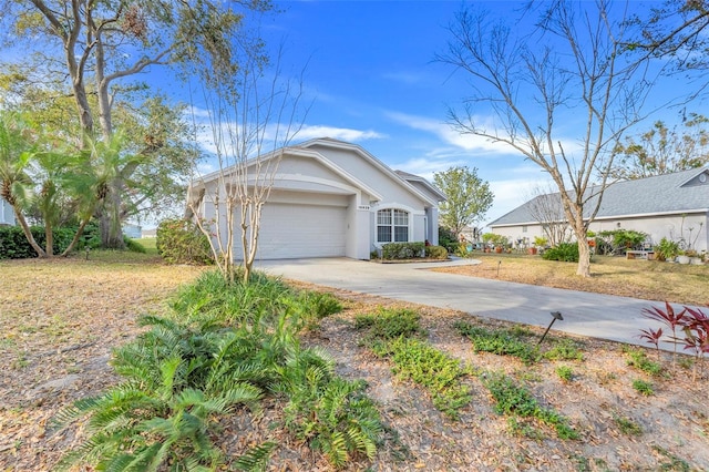 view of front of home featuring a garage, concrete driveway, and stucco siding