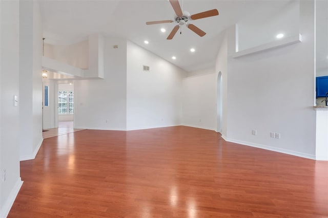 unfurnished living room featuring high vaulted ceiling, a ceiling fan, visible vents, and wood finished floors