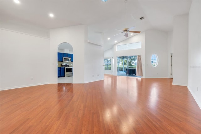 unfurnished living room featuring light wood-style floors, visible vents, high vaulted ceiling, and a ceiling fan