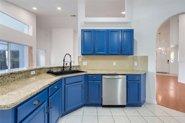 kitchen with dishwasher, blue cabinetry, and a sink