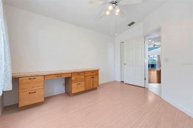 unfurnished office with visible vents, a ceiling fan, vaulted ceiling, light wood-type flooring, and built in desk