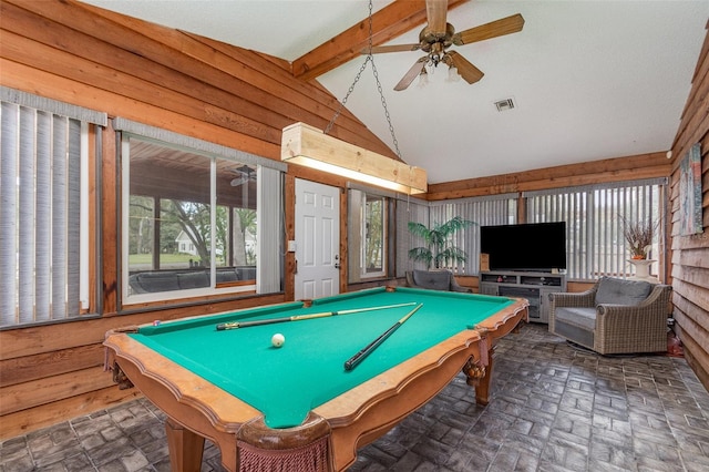 recreation room with brick floor, visible vents, lofted ceiling with beams, wood walls, and ceiling fan