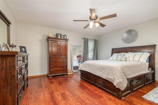 bedroom featuring a textured ceiling, dark wood-type flooring, and baseboards