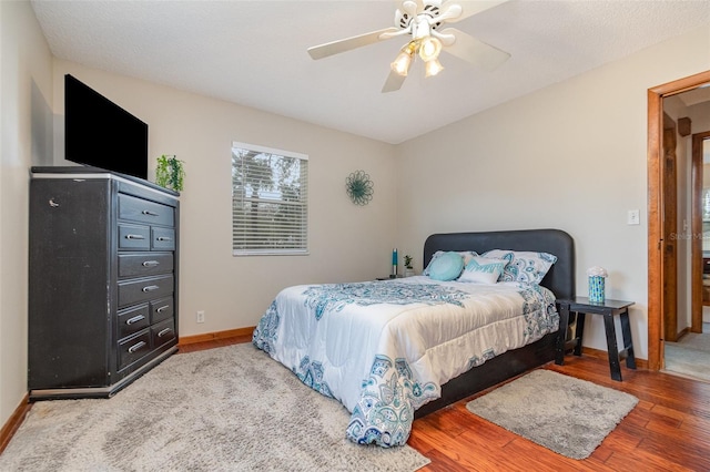 bedroom featuring ceiling fan, wood finished floors, and baseboards