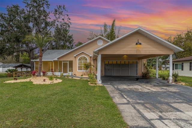 ranch-style house featuring driveway, a garage, and a yard