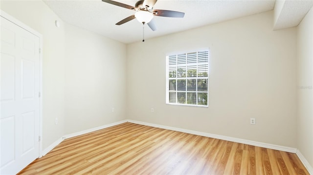 unfurnished room featuring light wood-style flooring, a textured ceiling, baseboards, and ceiling fan