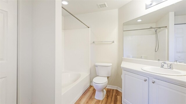 bathroom with vanity, wood finished floors, visible vents, baseboards, and toilet