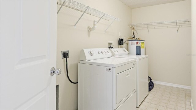 washroom featuring electric water heater, baseboards, light floors, laundry area, and separate washer and dryer