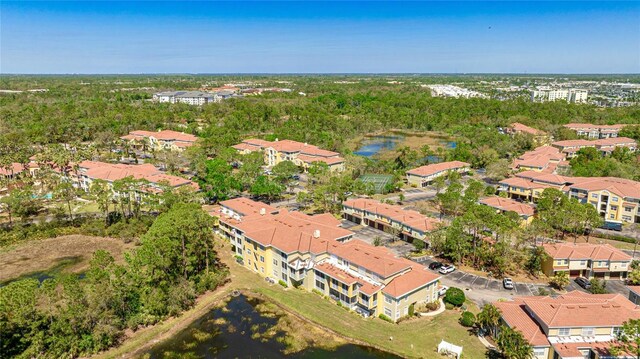 aerial view featuring a wooded view and a water view