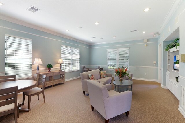 living area featuring visible vents, baseboards, light colored carpet, and crown molding