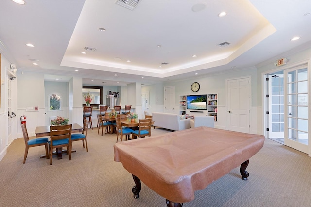 rec room with light carpet, wainscoting, and a tray ceiling