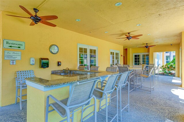 view of patio featuring a sink, french doors, and a ceiling fan