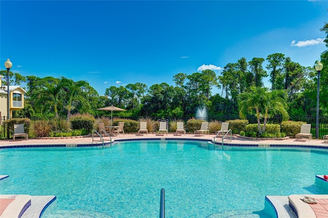 pool with a patio and fence